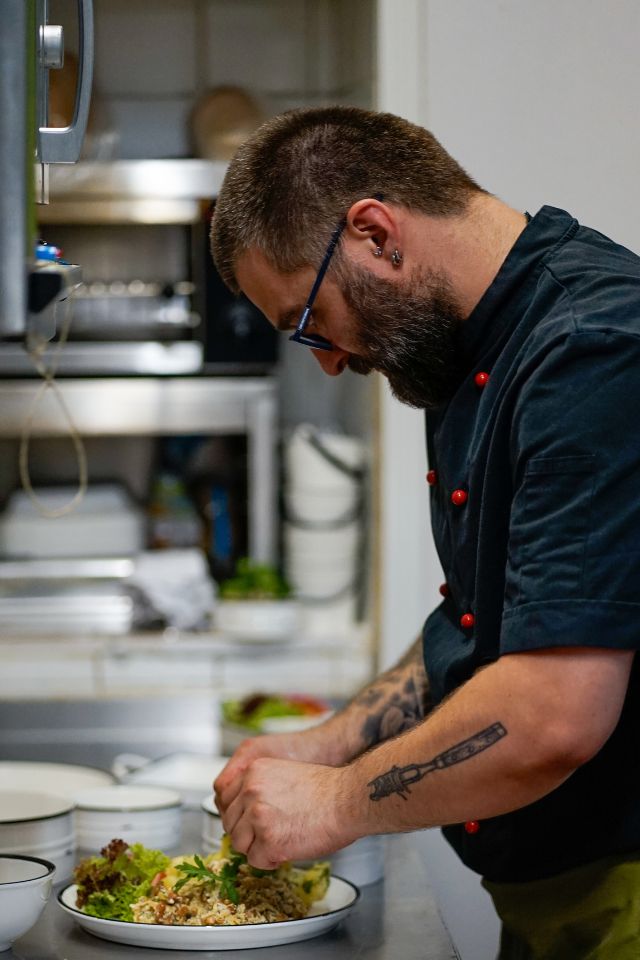 Küchenchef vom Ottakringer Schnitzelwirt bereitet eine Speise zu.